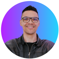 foto perfil de Mayk Brito sorrindo, de óculos, barba, camisa preta e fundo amarelo.